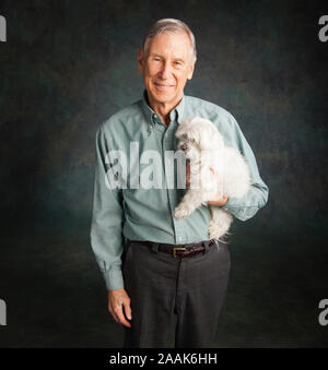 Portrait von älteren Mann mit Malteser Hund Stockfoto