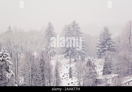 Ansicht von oben auf die Stadt Friedhof in Banska Bystrica, Slowakei in starker Schneefall Tag. Friedhof im Schnee. Blizzard in der Stadt. Stockfoto