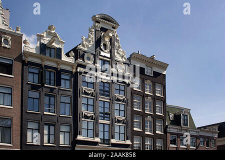 Blick auf die historische, traditionelle und typische Gebäude zeigen niederländische Architektur in Amsterdam. Es ist ein sonniger Sommertag. Stockfoto