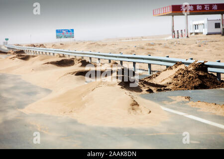 Schleichende Wüstenbildung. Sanddünen auf der anderen Seite der Autobahn in der Inneren Mongolei, Nordchina verbreitet. Stockfoto