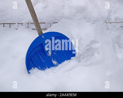 Big blue Kunststoff Schaufel für die Schneeräumung, stehend in einer großen schneeverwehung, close-up Stockfoto