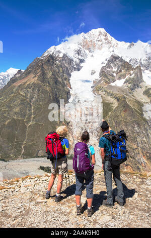 Ein Bergführer zeigt ein schnell sich zurückziehenden Gletscher auf dem Mont Blanc für Wanderer auf der Tour de Mont Blanc. Stockfoto