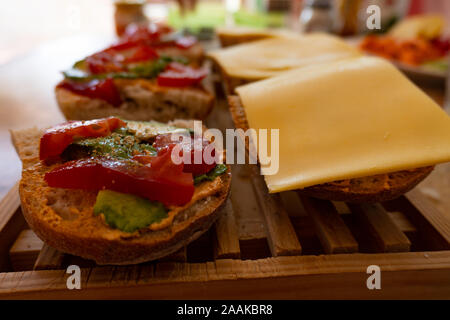Veganen Sandwiches mit Avocado, Tomaten und veganer Käse auf einem hölzernen Fach Stockfoto
