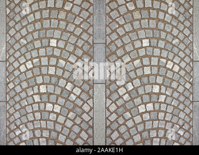 Neue Pflasterung mit grauen Steinplatten und kleinen Stein cube Blöcke mit Sand in geschwungene Form in einer Fußgängerzone verriegelt, Stockfoto