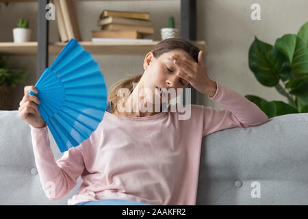 Überhitzte Mädchen mit Hand waver Hitze leiden. Stockfoto