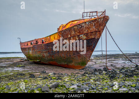 Ein rostiges Schiffswrack im Schlamm der Walney Kanal, von der Straße auf Roa Island, Cumbria, England, UK gesehen Stockfoto