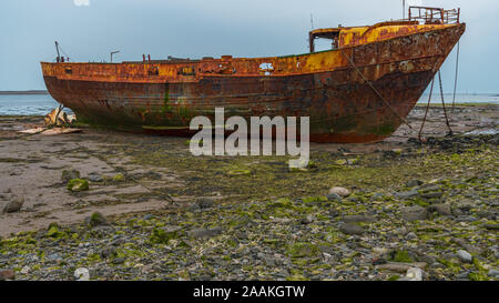 Ein rostiges Schiffswrack im Schlamm der Walney Kanal, von der Straße auf Roa Island, Cumbria, England, UK gesehen Stockfoto