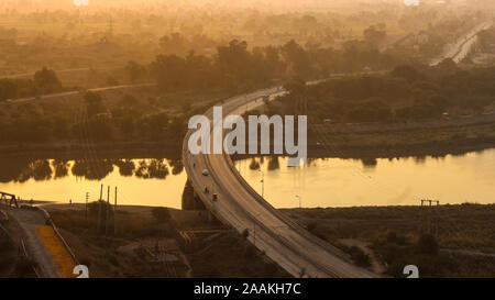 Einen schönen Blick auf den Fluss, eine Brücke und ein paar Bäume mit einer Reflexion, von dem Hügel. Stockfoto