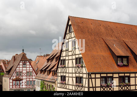 Nahaufnahme von traditionellen Fachwerkhäusern mit Fenstern, die mit Blumen und Biberschwanzdach für die Franken-Region dekoriert sind. Stockfoto