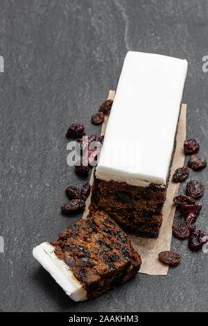 Obst Kuchen gekrönt mit Marzipan auf schwarzen Stein Tabelle Stockfoto