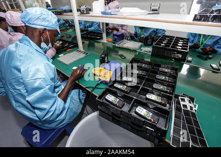 (191122) - mukono (Uganda), November 22, 2019 (Xinhua) - Ein Mitarbeiter Orte Bildschirme auf Telefonen in der Fabrik von engo Holdings Group begrenzt bei Namanve Industrial Park in Mukono, Uganda, an November 22, 2019. Chinesische Elektronikkonzern Engo Holdings Group Limited, am Freitag eröffnete ein 5 Mio. US-Dollar Fabrik in Uganda, die Handys und Laptops herstellen. (Foto durch Hajarah Nalwadda/Xinhua) Stockfoto
