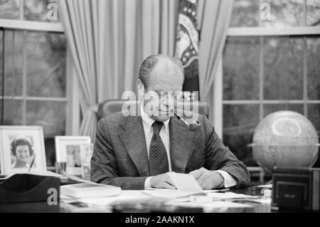 Us-Präsident Gerald Ford arbeitet an seinem Schreibtisch, das Rauchen einer Pfeife, White House, Washington, D.C., USA, Foto: Marion S. Trikosko, 6. Februar 1975 Stockfoto