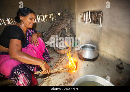 Eine Frau in einem abgelegenen Subsistenzwirtschaft Dorf auf einer Insel in den Sunderbans, der Ganges Delta im östlichen Indien. Sie ist Kochen auf einem traditionellen Cla Stockfoto