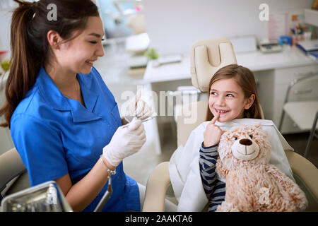 Zahnmedizinische Klinik. Kid lächelnde Mädchen sitts in der Zahnarztpraxis. Stockfoto