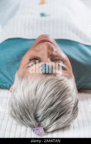 Heilung und Balancing chakren Therapie. Ältere Frau liegen auf Massage Tisch und genießen Chakra Heilung. Stockfoto