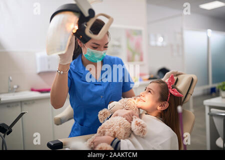 Kleines Kind an Stomatologie. Glückliches Mädchen mit Zahnarzt. Gesundheit Zähne Konzept. Stockfoto