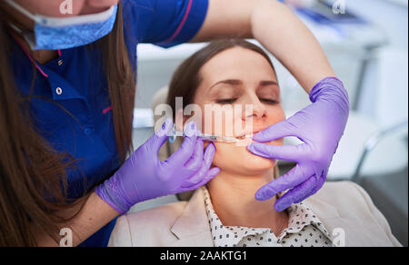 Botox Injektionen. Junge Frau, die kosmetische Injektion auf ihre Lippen. Stockfoto