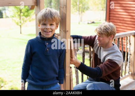 Vater und Sohn bauen Baumhaus im Garten Stockfoto