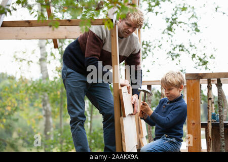 Vater und Sohn bauen Baumhaus im Garten Stockfoto