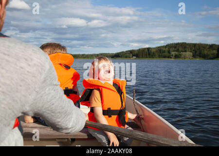 Nach Segeln mit aufgeregten Jungen auf dem Boot in See, Finnland Stockfoto