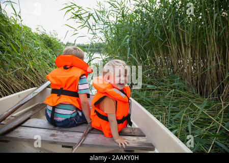 Brüder spielen auf dem Boot im Gras Feld günstig Stockfoto