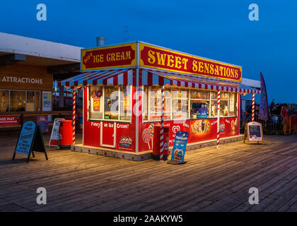 Bunte Nacht Ansicht Ansicht des Eis und Süßwaren shop auf Clacton Pier, Clacton-on-Sea. Stockfoto