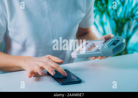 Frau Eingabe von Daten aus digitalen hand grip Dynamometer nach einer Stärke testen. Stockfoto