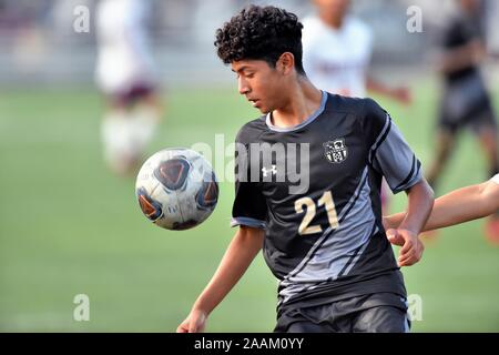 Spieler, die versuchen, einen erhöhten Ball zu kontrollieren, während sie versuchen, einen offensiven Ansturm am Leben zu halten. USA. Stockfoto