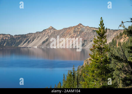Crater Lake blau mit roten Felsen Stockfoto