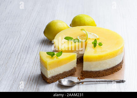 Hausgemachte Layered Lemon Cheesecake auf weissem Holztisch Stockfoto