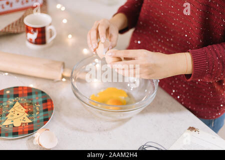 Frau Risse Ei über eine Glasschale Stockfoto