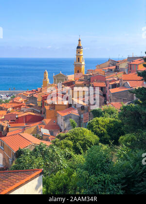 Sonnige Landschaft von Vieux Menton Stadtzentrum von oben, Saint Michel Basilika stehen heraus und Meer im Vordergrund. Stockfoto