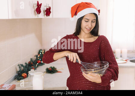 Frau schlagen, Eier mit einem manuellen Mixer Stockfoto
