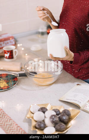 Weibliche Hände halten weiss Glas mit Mehl Stockfoto