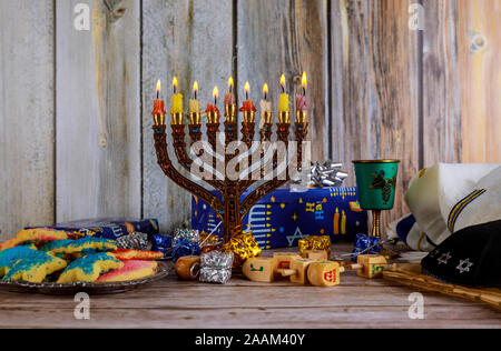 Hanukkah Kerzen, jüdischen Feiertagen traditionellen Kandelaber, Donuts und Holz- dreidels Kreisel. Stockfoto