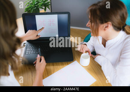 Vedische Astrologie jyotisha Beratung. Das Sitzen am Schreibtisch vor dem Laptop und im Geburtshoroskop suchen. Stockfoto