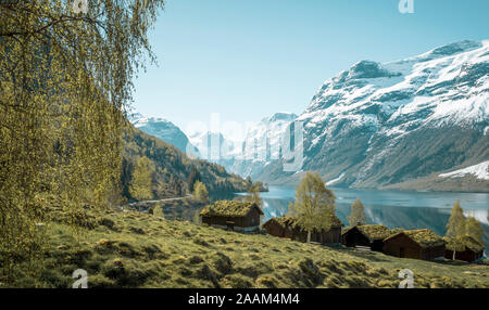 Schöne norwegische Landschaft mit alten Bauernhof, den See und die Berge Stockfoto