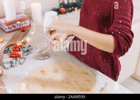 Nahaufnahme der womans Hand gießen Zimt im Teig Stockfoto