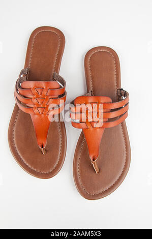 Frauen Paar braune Leder flache Sandalen auf hellem Hintergrund isoliert. Freizeitschuhe fashion Zubehör Schuhe. Stockfoto