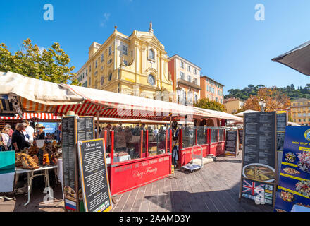 Tabellen mit Antiquitäten und Sammlerstücke in der überdachten Flohmarkt neben Straßencafés in der Cours Saleya in Nizza, Frankreich. Stockfoto