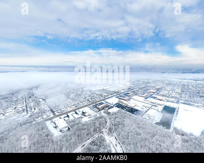 Eine Antenne/drone Blick über eine kleine Stadt in Illinois auf der Suche nach einem Schneesturm mit den Wolken starten zu löschen und die Stadt bedeckt. Stockfoto