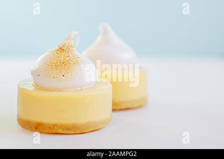 Zitronengelb cheesecake Dessert mit Dekoration aus Eiern Weiß Creme gebraten auf der einen Seite oben auf hellen blauen Hintergrund und Platz für Text Stockfoto