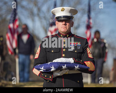 Des Moines, Iowa, USA. 22 Nov, 2019. US Marine Corps Erster Sgt. MICHAEL SÖDERGREN hält eine gefaltete United Fahne Staaten während des reinterment Service des US Marine Corps finden Private Channing Whitaker in Glendale Friedhof. Die Flagge wurde zu Whitaker's Familie vorgestellt. Whitaker starb in der Schlacht um tarawa an November 22, 1943. Er war auf Betio Insel begraben, in den Gilbert Inseln, und seine Überreste wurden im März 2019 erholt. Er war durch einen DNA-Abgleich mit Hinterbliebene in Iowa identifiziert. Credit: ZUMA Press, Inc./Alamy leben Nachrichten Stockfoto