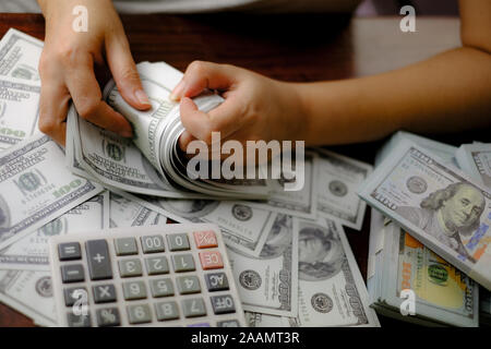 Unternehmer Frauen zählen Geld auf einem Stapel von 100 US-Dollar Banknoten viel Geld Stockfoto