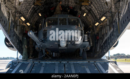 Ein HH-60 Pave Hawk Hubschrauber in die 305Th Rescue Squadron (RQS), Davis-Monthan Air Force Base, Ariz zugewiesen ist, sitzt in einem C-17 Globemaster III des 436Th Airlift Wing, Dover Air Force Base, Dela, bei MacDill Air Force Base, Fla., Nov. 20, 2019 zugeordnet. MacDill bewirtete die 305th RQS, wie sie in einem gemeinsamen Kraft Einsatz Übung mit US Army Special Forces Mitglieder teilnahmen. (U.S. Air Force Foto von Airman 1st Class Ryan C. Grossklag) Stockfoto