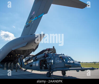 Us Air Force Piloten ein HH-60 Pave Hawk Hubschrauber in die 305Th Rescue Squadron (RQS), Davis-Monthan Air Force Base, Ariz zugewiesen sind, auf eine C-17 Globemaster III der 436th Airlift Wing (AW), Dover Air Force Base, Dela, bei MacDill Air Force Base, Fla., Nov. 20, 2019 zugeordnet. Die 436Th AW unterstützt die Abfahrt der 305th RQS nach einem gemeinsamen Kraft Einsatz Übung. (U.S. Air Force Foto von Airman 1st Class Ryan C. Grossklag) Stockfoto