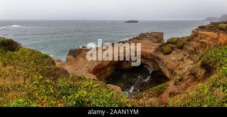 Panoramablick von Devil's Punchbowl Bogen während eines verregneten Sommertag. In Otter Rock, Oregon Küste, Vereinigten Staaten von Amerika übernommen. Stockfoto