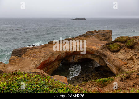 Anzeigen von Devil's Punchbowl Bogen während eines verregneten Sommertag. In Otter Rock, Oregon Küste, Vereinigten Staaten von Amerika übernommen. Stockfoto