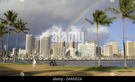 Honolulu, Hawaii, USA - 10. Juni 2015: Blick auf Honolulu's Skyline mit einem wunderschönen Regenbogen über den Himmel von der Magic Island Lagune Stockfoto