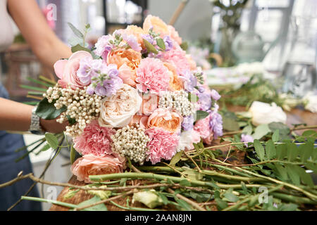 Europäische floral Shop Konzept. Floristin Frau schafft Schönen Blumenstrauß aus gemischten Blumen. Schönen frischen Haufen. Bildung, master class und Floristik Stockfoto